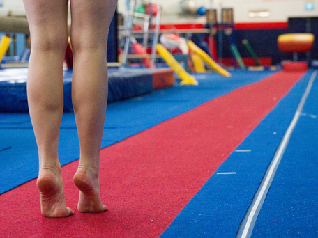 Gymnastics student standing at the end of the long sprung track